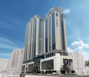 沙迦Pullman Sharjah的一座高大的建筑,前面有棕榈树