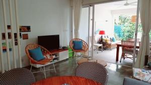 罗驰诺尔Villa Ximun的客厅配有藤椅和电视
