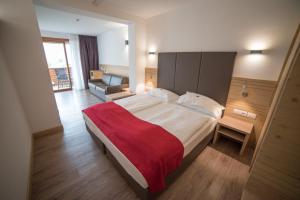 菲耶梅堡奥利派尼克酒店的一间卧室配有一张带红色毯子的大床