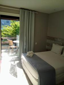 布希奥斯贝姆布基亚斯旅馆的一间卧室配有一张床,阳台配有桌子