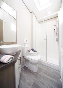 南塞尔尼Lavender Lodge的白色的浴室设有卫生间和水槽。