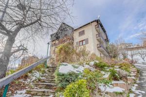 埃姆布能Les Fauvettes - appartement vue imprenable sur montagne的山上的一座建筑,楼梯上积雪