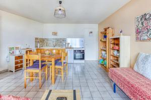 埃姆布能Les Fauvettes - appartement vue imprenable sur montagne的厨房以及带桌椅的起居室。