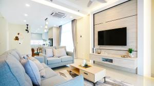 迪沙鲁Desaru Exclusive Elegant theme by Joyfully 2M8的客厅配有蓝色的沙发和电视