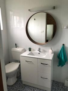 麦夸里港Fi's Beach House的一间带卫生间、水槽和镜子的浴室