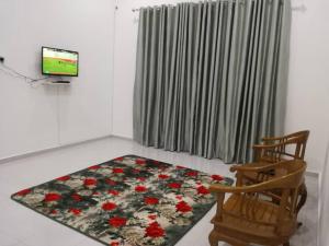 哥打巴鲁Homestay Pasir Tumboh Kota Bharu的一间带电视和地毯的客厅