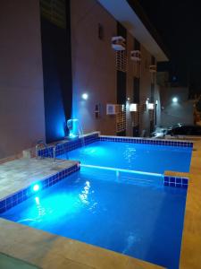 瓜鲁雅Pousada Maré Enseada的夜间酒店游泳池
