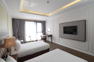 金瓯Phu Cuong Hotel Ca Mau的酒店客房设有两张床和一台平面电视。