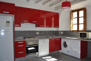 埃斯特连克斯萨波萨达度假屋的一间带红色橱柜和洗衣机的厨房