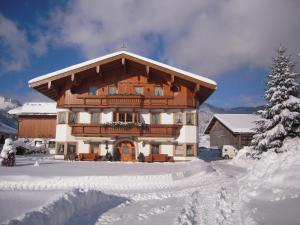 克森施密特小屋旅馆的一座大型木制建筑,在雪中设有阳台