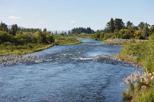 图朗伊Turangi Leisure Lodge的两边都有岩石和树木的河流