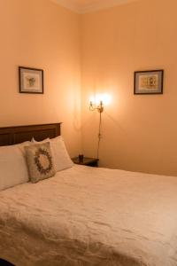 第聂伯罗Ekaterinoslav的一间卧室配有一张带白色床单和一盏灯的床。