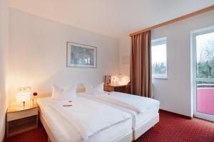 埃尔丁Andante Hotel Erding的酒店客房设有一张白色大床和一个窗户。