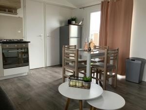 东卡佩勒Chalet Zonnig Zeeland的厨房配有桌椅和冰箱。