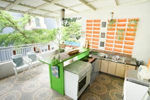 玛琅INNI Homestay的一个带绿色柜台的厨房和一个阳台