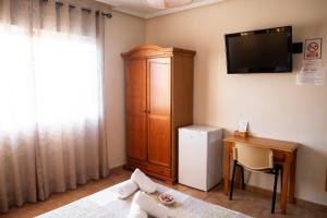 洛斯阿尔卡萨雷斯伊尔科尔多贝斯膳食公寓的客房设有电视、床和书桌。