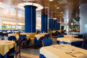比比翁Hotel Luna的餐厅设有桌椅和蓝色柱子