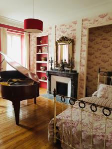 阿尔比切斯路易斯旅馆的配有床、镜子和钢琴的房间