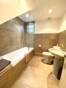 切尔滕纳姆Laurel House的带浴缸、卫生间和盥洗盆的浴室