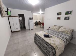 弗洛里亚诺波利斯Casa em Florianópolis的一间卧室配有一张床,厨房配有冰箱