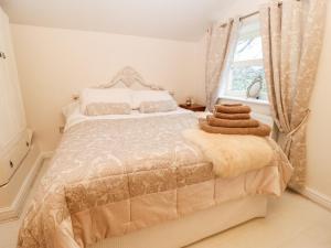 奥尔德姆Clock Cottage的白色卧室设有一张带窗户的床
