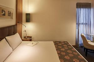 戈亚尼亚Oft Alfre hotels - Goiânia的卧室配有床、椅子和窗户。