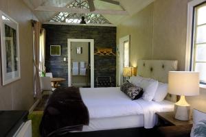 金吉拉金吉拉桂冠旅馆的卧室配有白色的床和砖墙