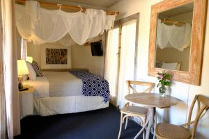 金吉拉金吉拉桂冠旅馆的一间卧室配有一张床、一张桌子和一面镜子