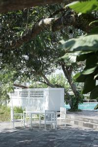 马格朗Sevilla Resort Magelang的树下一组白色的桌椅