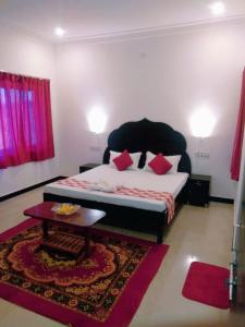 乌代浦Amritchandra homestay and hostel的一间卧室配有一张带红色枕头的床和一张桌子