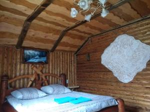 米库利钦Берлога 2的木制客房内的一间卧室,配有一张床