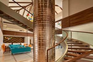 德瓦尔卡Hawthorn Suites by Wyndham Dwarka的螺旋楼梯,位于带大堂的大楼内