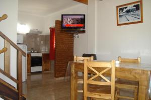 本塔纳山村Cabañas Aldea Serrana的客厅配有桌子和墙上的电视