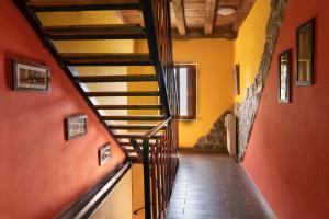 切尔维尼亚诺德尔夫留利维奇奥制康芬住宿加早餐旅馆的走廊,楼梯位于一座拥有橙色墙壁的房子里