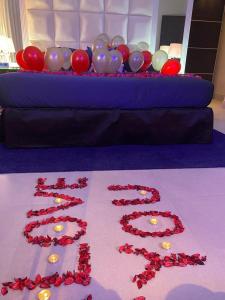 利雅德Dana Hotel & Residences的一张桌子,上面放着红玫瑰和气球