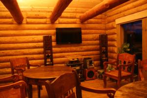 伊格纳利纳米斯基尼柯斯乡村民宿的小木屋内带桌子和电视的客厅