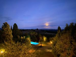 PalazzoneAgriturismo Spazzavento的享有花园泳池的夜间景致