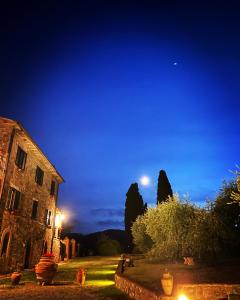 PalazzoneAgriturismo Spazzavento的天空中月亮的古老建筑的夜景