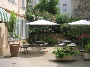 戛纳尚特克莱尔酒店的一个带桌椅和遮阳伞的户外庭院。