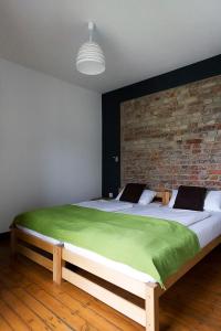 比勒费尔德Schickes Bielefeld Zentrum Appartement的一间卧室设有一张带砖墙的大床