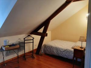 Ferme des capucines的一间卧室配有一张床,铺有木地板