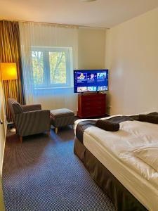 斯武普斯克Słupsk forest PREMIUM HOTEL APARTAMENT M6 - Kaszubska street 18 - Wifi Netflix Smart TV50 - two bedrooms two extra large double beds - up to 6 people full - pleasure quality stay的配有一张床和一台平面电视的酒店客房