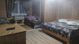 沃罗赫塔Sadyba Geredzhuka的客房设有两张床、一张桌子和一张沙发。