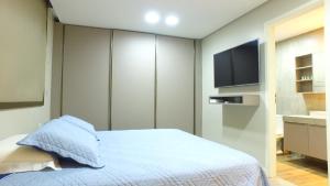 拉巴拉德纳圣米格尔Barra Bali Apartamento 06 - Paraíso à Beira Mar的一间卧室配有一张床和一台平面电视