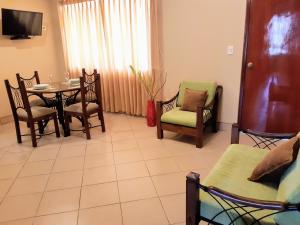 皮斯科Sol de Paracas Apart Hotel的客厅配有桌椅