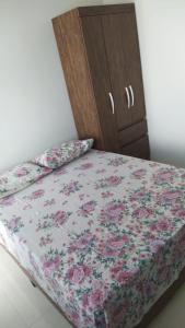 帕苏斯Recanto das Gerais的一张带花卉床单和橱柜的床