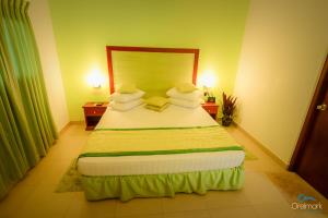 阿维瑟韦勒西塔瓦卡摄政酒店的卧室配有一张带绿床单和枕头的大床。