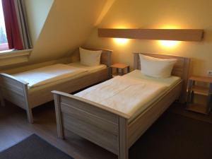 奥斯纳布吕克西门子酒店的小型客房配有两张床和两张桌子。