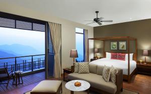 KurseongTaj Chia Kutir Resort & Spa Darjeeling的酒店客房设有一张床和一个阳台。