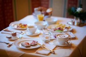 莱赫阿尔贝格Hotel Garni Schneider的餐桌,盘子上放着食物和咖啡